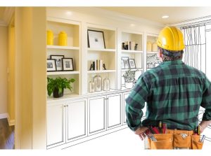 man in hard hat looking at completed remodel project